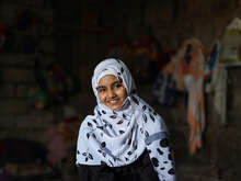 A girl poses for a portrait and smiles at the camera.